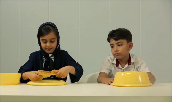 یک فریم از ویدیوی معروف اشتراک غذا توسط بچه ها که مصداقی از سنجش هوش تیمی در آن ها است.